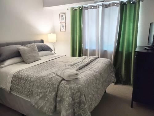 a bedroom with a large bed with green curtains at Charming Condo in Central Raleigh in Raleigh