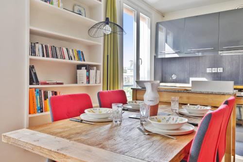 une table à manger avec des chaises rouges et une table en bois dans l'établissement Appartement Charenton - Welkeys, à Paris