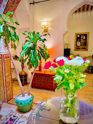two vases with flowers on a table in a room at Riad Al-Qurtubi in Tangier