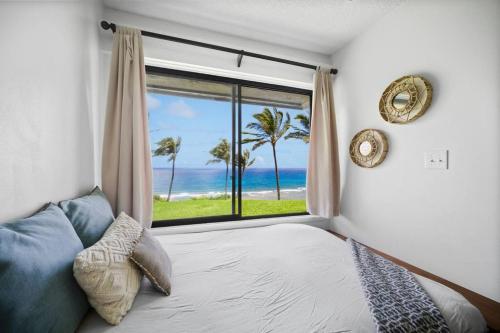 a bedroom with a bed and a view of the ocean at Ocean View at Sea Lodge J4 in Princeville