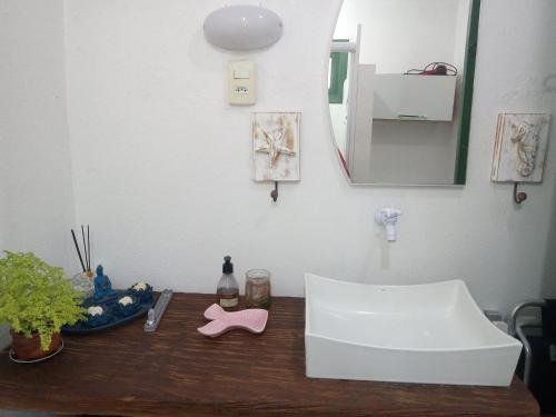 a bathroom counter with a sink and a mirror at Kitnet da Elô in Tramandaí