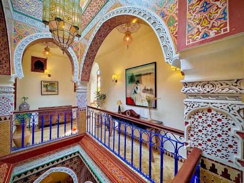 an ornate staircase in a building with a painting at Hostel Al-Qurtubi in Tangier