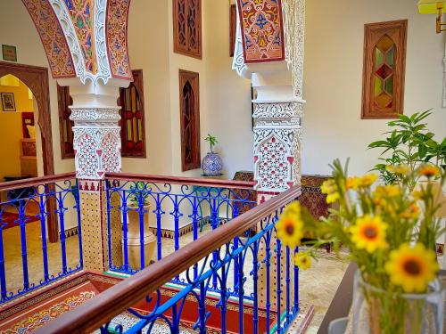 a staircase with a blue and white railing and flowers at Hostel Al-Qurtubi in Tangier