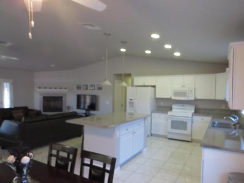 a kitchen and living room with white cabinets and a couch at Panoramic Night Lights in Joshua Tree