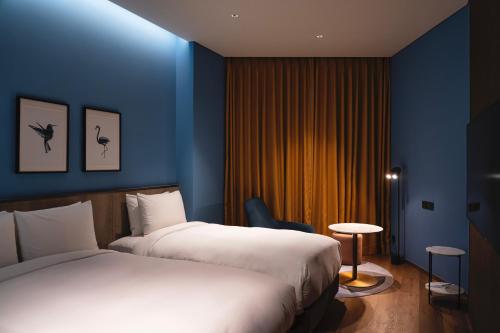 a hotel room with two beds and a blue wall at voco Seoul Gangnam by IHG in Seoul