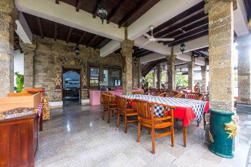 a dining room with a table and chairs at Hotel Sari Bunga in Legian
