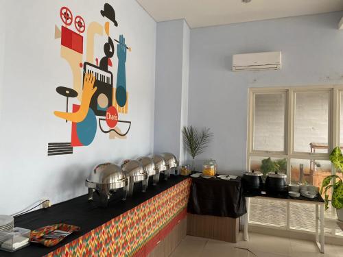 eine Küche mit einer Theke mit Töpfen und Pfannen in der Unterkunft Votel Hotel Charis Tuban in Jembel