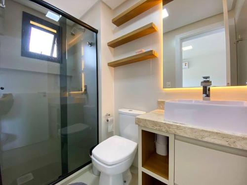 een badkamer met een toilet, een wastafel en een douche bij Apto central e próximo à praia in Torres