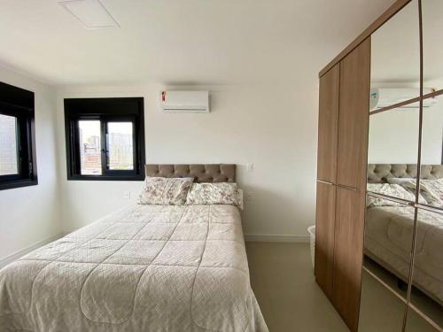 ein Schlafzimmer mit einem großen Bett und einer Kommode in der Unterkunft Apto central e próximo à praia in Torres