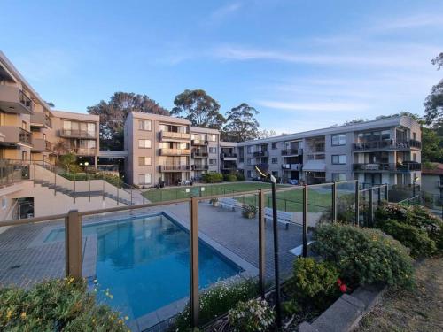 an apartment complex with a swimming pool and buildings at The Poplars, Pool Access Getaway in Nelson Bay