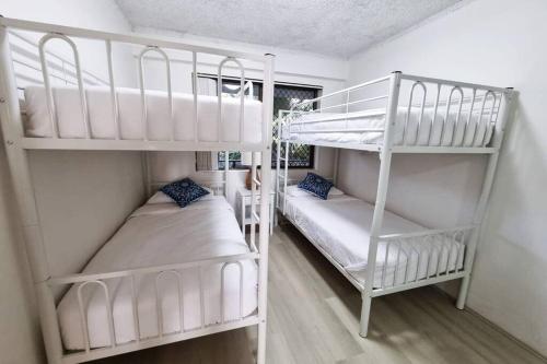 two bunk beds in a small room with at The Poplars, Pool Access Getaway in Nelson Bay