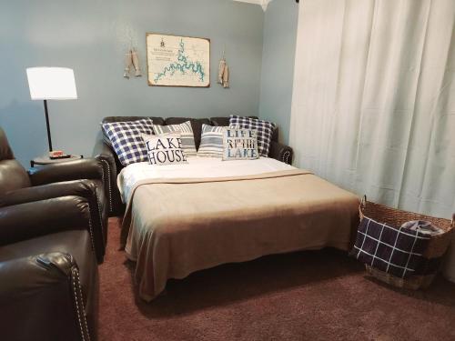 a bedroom with a bed with pillows and a chair at Cozy Lakeside Getaway - Outdoor Theater - Free Early Check-In- 4min to Silver Dollar City in Branson