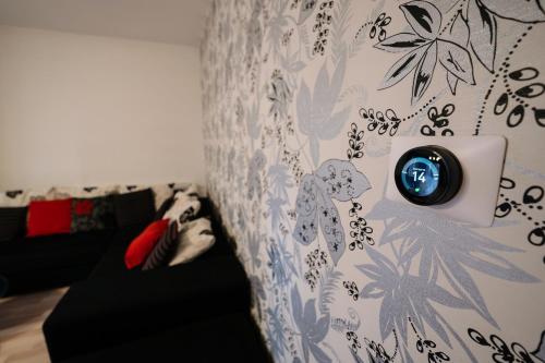 a woman laying on a couch with a clock on a wall at Quiet 3-Room Apt - 2 Parking Spaces - 5 Min Bus in Floreşti