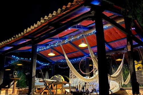 a patio with a hammock under a pergola at night at Glamping Yerbabuena in Toca