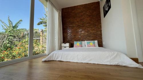 a bedroom with a bed and a large window at Huyen's Home in Ba Ria