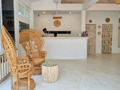 a woman standing at a counter in a room with chairs at Elephant Beach Club & Resort Samui in Chaweng