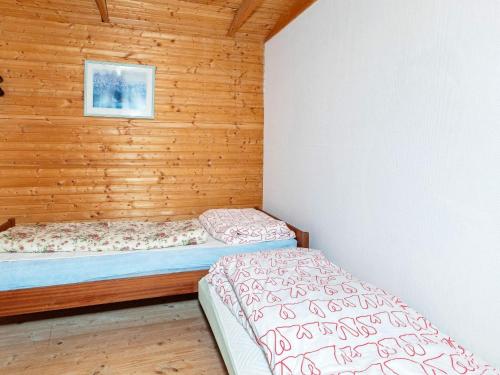 twee bedden in een kamer met houten wanden bij Holiday home Farsø IX in Farsø