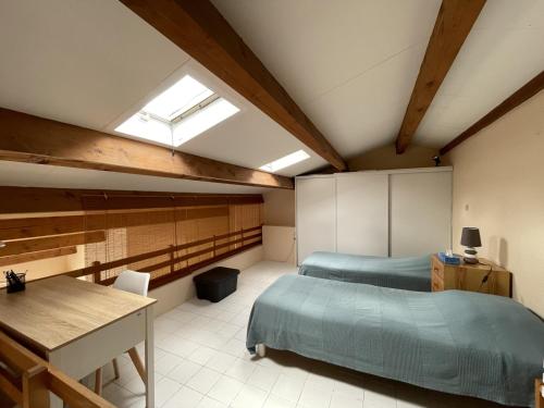 une chambre avec deux lits et un bureau et une fenêtre dans l'établissement Superbe 2 pièces mezzanine, près plage, parking inclus, animaux admis - FR-1-338-528, à Sète
