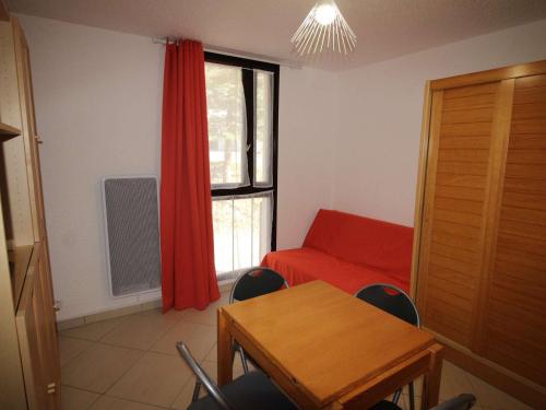 オリにあるAppartement Auris, 1 pièce, 3 personnes - FR-1-297-335の赤いソファ、テーブル、窓が備わる客室です。