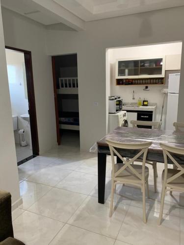 a kitchen and dining room with a table and chairs at Apartamento Maranduba in Ubatuba