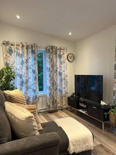 a living room with a couch and a flat screen tv at Le St-Augustin - à 15 minutes des Outlets de Mirabel in Mirabel