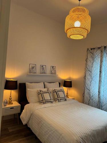 um quarto com uma cama com 2 candeeiros e um lustre em Le St-Augustin em Mirabel