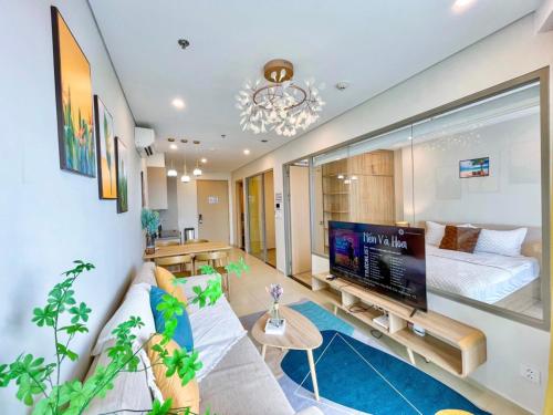 a living room with a couch and a tv at The Song Vũng Tàu - Luxury House in Vung Tau