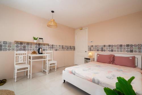 1 dormitorio con 1 cama, mesa y sillas en HY Local Budget Hotel by Hoianese - 5 mins walk to Hoi An Ancient Town, en Hoi An