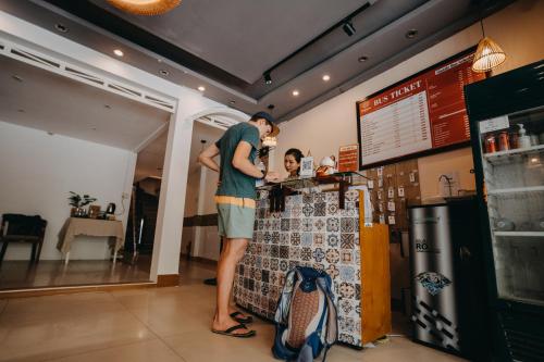 a man standing at a counter in a store at HY Local Budget Hotel by Hoianese - 5 mins walk to Hoi An Ancient Town in Hoi An