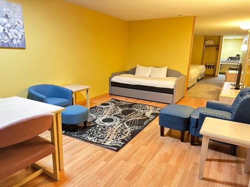 a room with a bed and two chairs and a table at Timberland Inn & Suites in Castle Rock