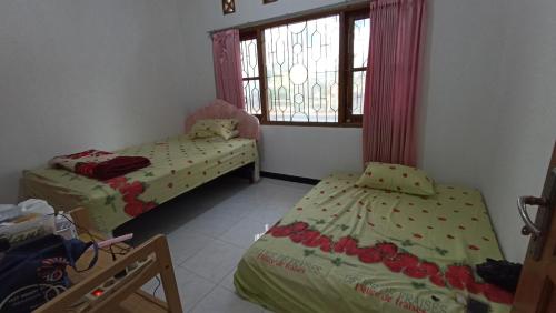 2 aparte bedden in een kamer met een raam bij Villa Ohana Batu in Batu