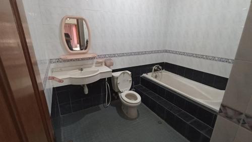 a bathroom with a sink and a toilet and a bath tub at Villa Ohana Batu in Batu