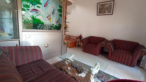 a living room with two couches and a glass table at Villa Ohana Batu in Batu
