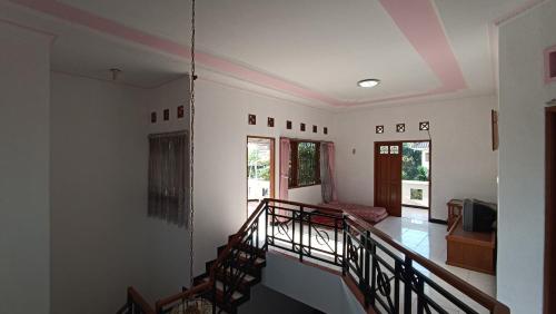 a room with a staircase and a living room at Villa Ohana Batu in Batu