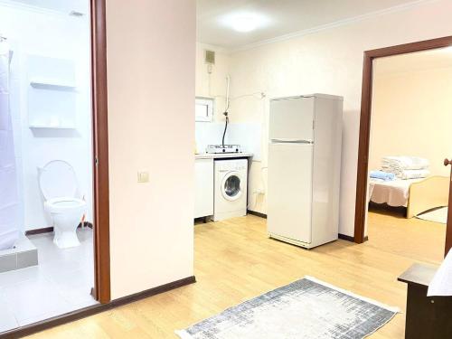 a kitchen with a refrigerator and a toilet in a room at Town House, metro Raiymbek in Almaty