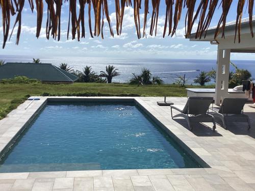 a swimming pool with a view of the ocean at La Suite Vue Lagon in Uturoa