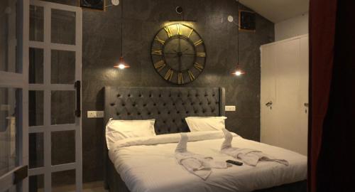 a bedroom with a bed with a large clock on the wall at The Bohemian Casa Dehradun in Dehradun