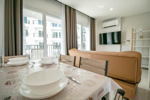 - une salle à manger avec une table et des plats blancs dans l'établissement Mantra Beach Condominium Suite 2 - Mae Phim, à Ban Tha Fat