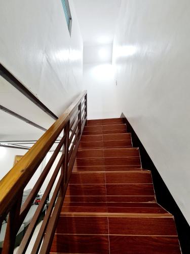 a staircase in a building with brown wooden stairs at Furnished House in Calapan City Subdivision near ROBINSONS Mall L33 in Calapan