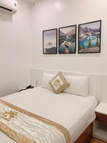 a bedroom with a bed with four pictures on the wall at Lagi Sunrise Hotel in La Gi