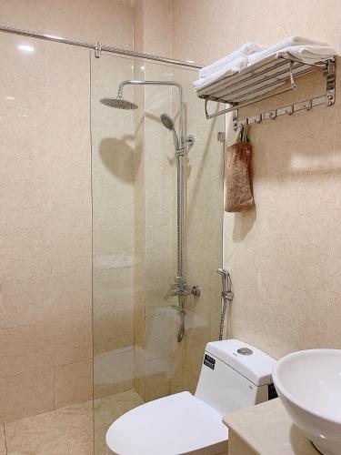 a bathroom with a shower and a toilet and a sink at Lagi Sunrise Hotel in La Gi