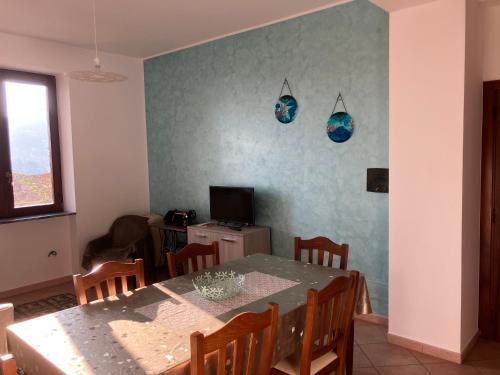 comedor con mesa y TV en Casa Alzira, en San Lazzaro Agerola