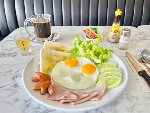 a plate of food with eggs and ham and toast at Air Diamond Hotel in Ban Nong Khong