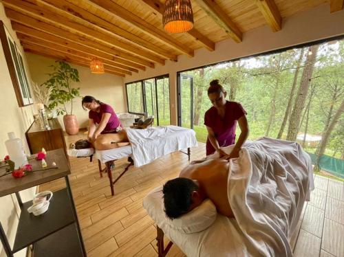 two women in a room with a person getting a massage at La Estela Bubble Glamping in Mazamitla