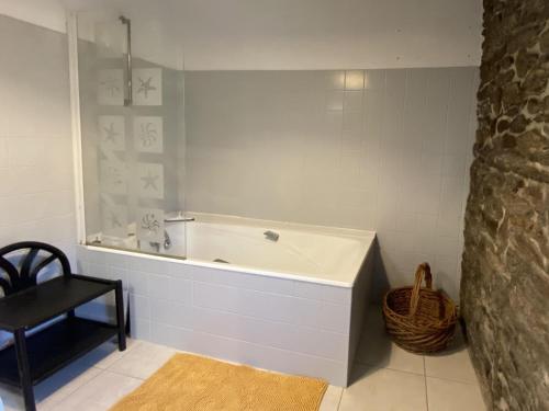 La salle de bains est pourvue d'une baignoire et d'une chaise noire. dans l'établissement Gite in Ploneour-Lanvern, à Plonéour-Lanvern