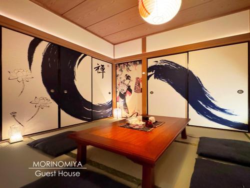 a room with a table and paintings on the wall at guesthouse森之宮【青丸】 in Osaka