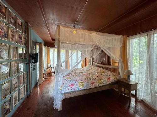 a bedroom with a bed with a canopy at SukhothaiNeeDee FarmCafe in Sukhothai