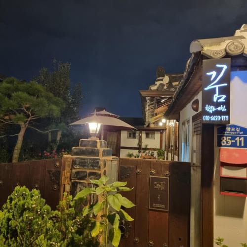 a sign in front of a building at night at Hanok Dream in Jeonju