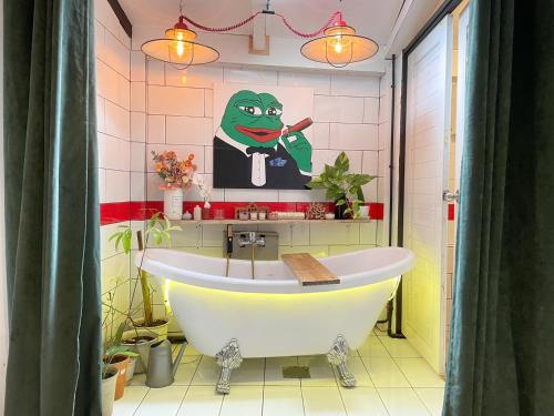 a bathroom with a tub and a painting of a frog at Dominol House l 5 min to Nimman l MAYA l Old Town l 附近的房子 in Chiang Mai