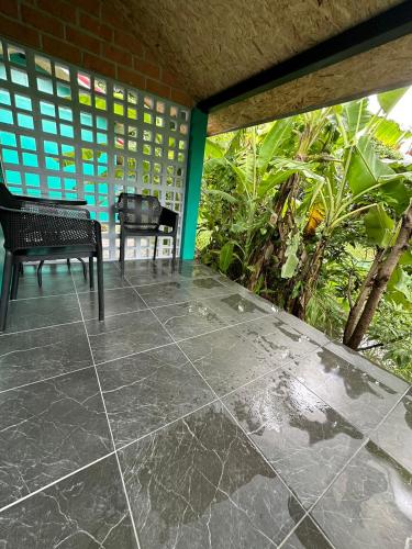 a patio with a bench and a table and chairs at SukhothaiNeeDee FarmCafe in Sukhothai